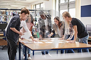 Group Of College Students Collaborating On Project In Library