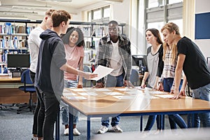 Group Of College Students Collaborating On Project In Library