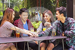 Group of college students joining hands together