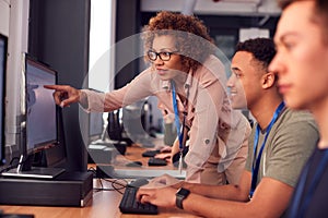 Group Of College Students With Tutor Studying Computer Design Sitting At Monitors In Classroom photo