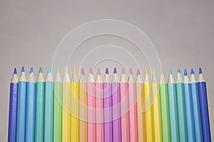 Group of color pencild laying in row striaght line made by pencil tips with grey background close up, Color pancils, copy space,