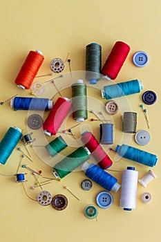 A group of colored sewing things on a yellow background