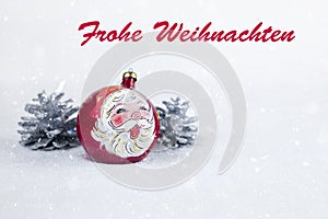 Group of colorful Christmas ball with drawing of Santa Claus and pines with text in German `Frohe Weihnachten`