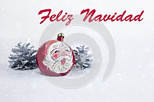 Group of colorful Christmas ball with drawing of Santa Claus and pines with text in Spanish `Feliz Navidad`