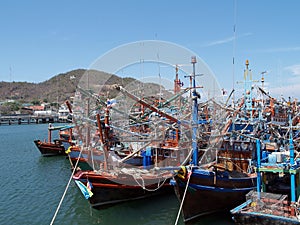 group of colorful fishing boats with fishing equipment mooring at jetty