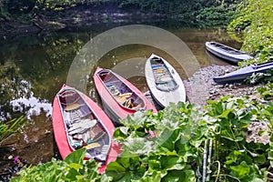 A group of colorful kayaks on the river bank