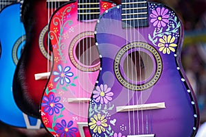 A group of colorful painted mexican made guitars