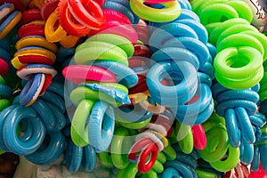 Group of colorful plastic life buoys tied together.