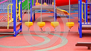 Group of colorful playground climbing equipment with balance bridge on rubber floor in outdoors playground area at kindergarten