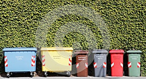 Group of coloured recycling bins on the street for paper plastic organic dry can and glass in Italy