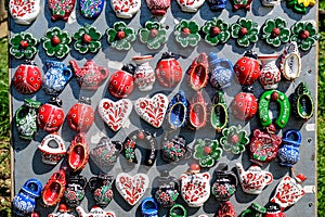 Group of colourful hand painted mixed magnets and suvenirs displayed for sale at a traditional weekend market in Bucharest,