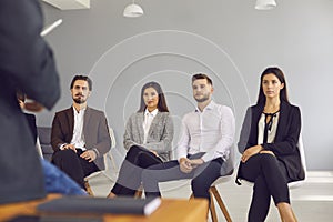 Group of company workers listening to businessman or executive manager making presentation or training