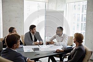 Group of concentrated happy multiracial business people discussing strategy.