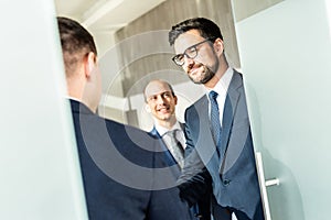 Group of confident business people greeting with a handshake at business meeting in modern office or closing the deal
