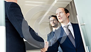 Group of confident business people greeting with a handshake at business meeting in modern office or closing the deal