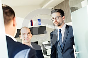 Group of confident business people greeting with a handshake at business meeting in modern office or closing the deal