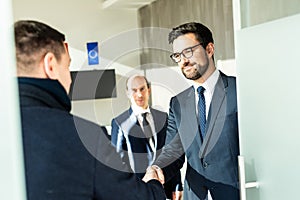 Group of confident business people greeting with a handshake at business meeting in modern office or closing the deal