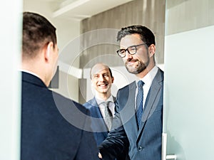 Group of confident business people greeting with a handshake at business meeting in modern office or closing the deal