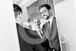 Group of confident business people greeting with a handshake at business meeting in modern office or closing the deal