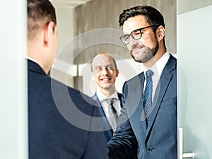 Group of confident business people greeting with a handshake at business meeting in modern office or closing the deal