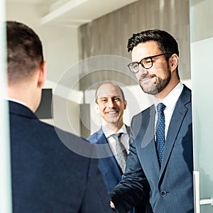 Group of confident business people greeting with a handshake at business meeting in modern office or closing the deal