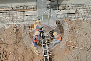 Group of construction workers casting for ground beam