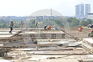 Group of construction workers fabricating floor slab reinforcement bar and formwork