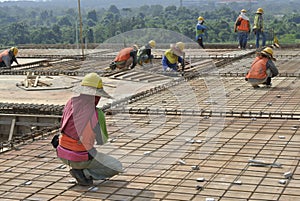 Group of construction workers fabricating floor slab reinforcement bar and formwork