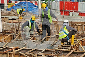 Group of construction workers fabricating ground beam formwork