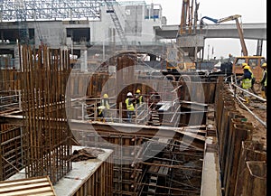 A group of construction workers pouring concrete into pile cap formwork