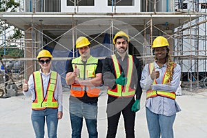 Group of construction workers raise finger thumb up with a smile while standing together in front of a building