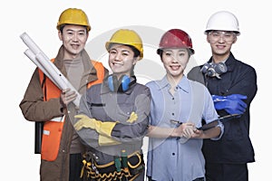 Group of construction workers standing against white background, smiling, portrait