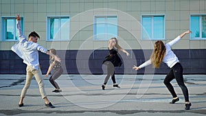Group of contemporary dancers freestyling outside in summertime.