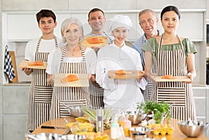 Group of cooks posing with salmon fillet on board