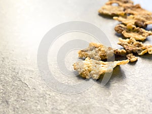 A group of corn flakes on a gray floor