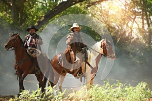 A group of cowboys on horseback with guns