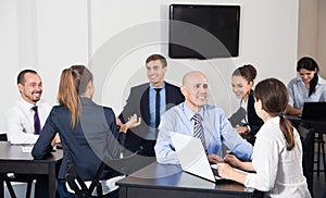 Group of coworkers with laptops on business project in office