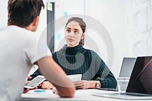 Group of coworkers looking at computer monitor while working in office