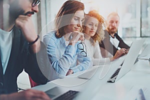 Group of coworkers working together on new business presentation at sunny meeting room.Horizontal.Blurred background.