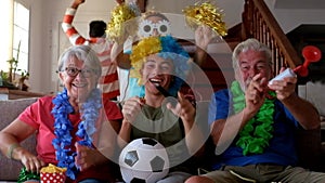 Group of crazy and coloured football supporter celebrate and exult during the match - mixed ages of caucasian people family and