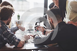 Group of creative friends sitting at wooden table. People having fun while playing board game