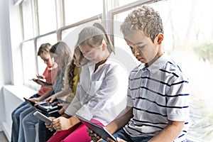 Group of curious children watching stuff on the tablet screen