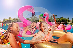 Group of cute kids swim in pool on inflatable toys photo