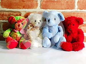A group of cute teddy bears sitting together against with wallpaper