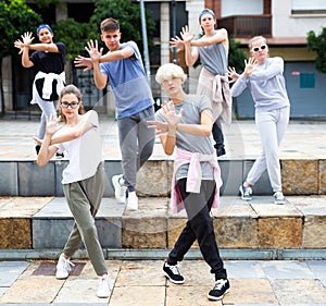Group of dancing teenagers posing at street. Hip hop dancers