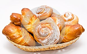 Group of delicious cinnamon rolls in basket isolated
