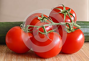 A group of delicious red tomatoes, arranged on a bamboo plate.