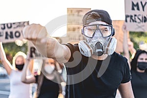 Group of demonstrators on road from different cultures fight for human rights during coronavirus outbreak - Focus on gas mask