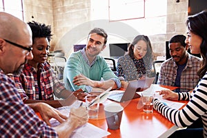 Group Of Designers Having Meeting Around Table In Office