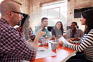 Group Of Designers Having Meeting Around Table In Office